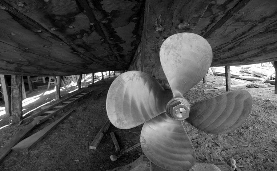 A view of the propeller in a wooden boat.