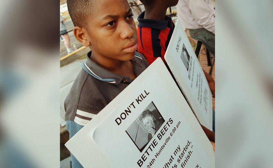 A kid protests against Betty Lou’s execution.