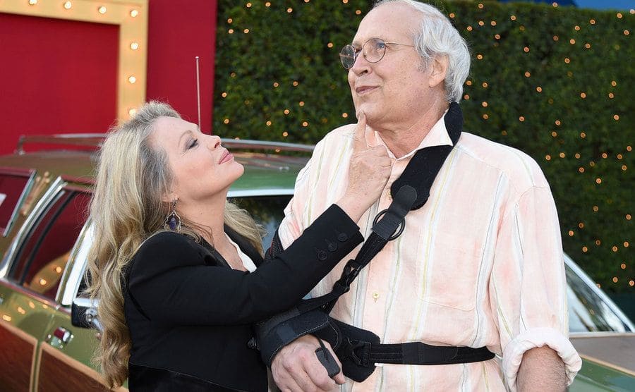 Beverly D'Angelo and Chevy Chase make jokes as they pose together during the premiere of