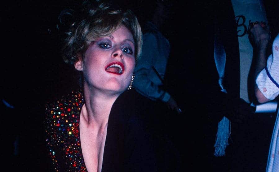 Beverly D'Angelo poses exaggeratedly for the photographer at an event.