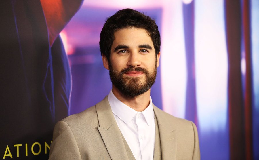 Darren Criss wearing a beige suit at a movie premiere.