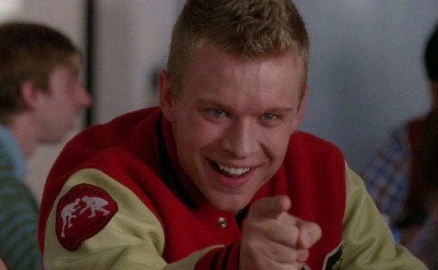 Jesse Luken in a football hoodie pointing a finger on the set of Glee.