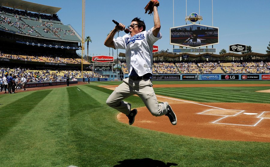 Johnny Knoxville speaks to the crowd at a baseball game.