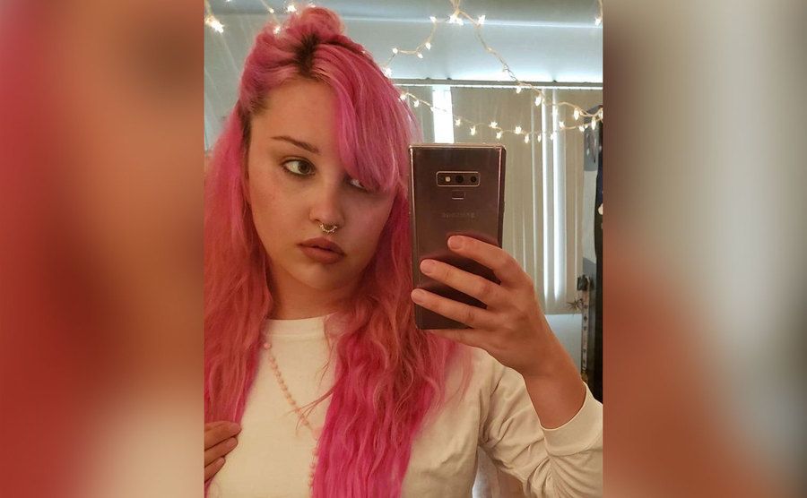 A mirror selfie of Amanda Bynes with hot pink hair.