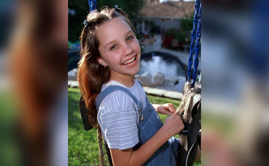 Amanda Bynes as a little girl on a swing.