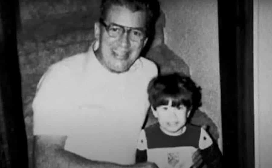 A younger John sits with his son.
