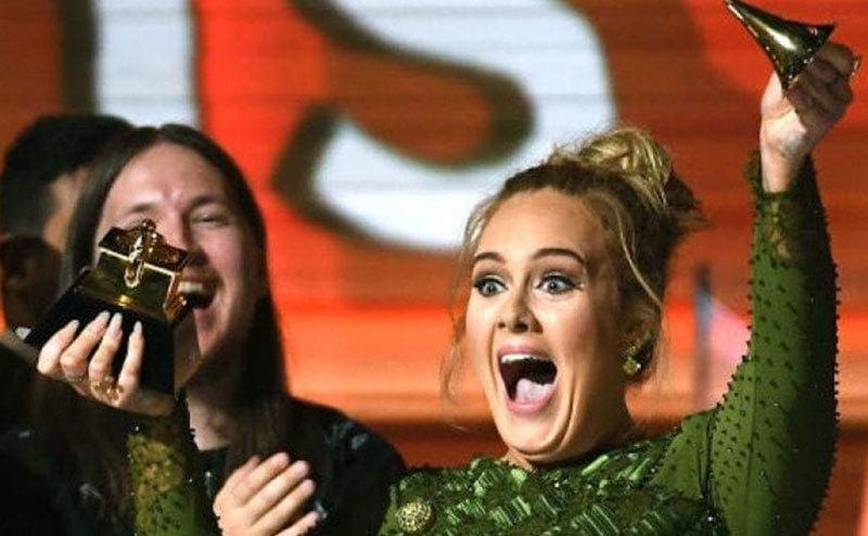 Adele laughs as she breaks her Grammy.
