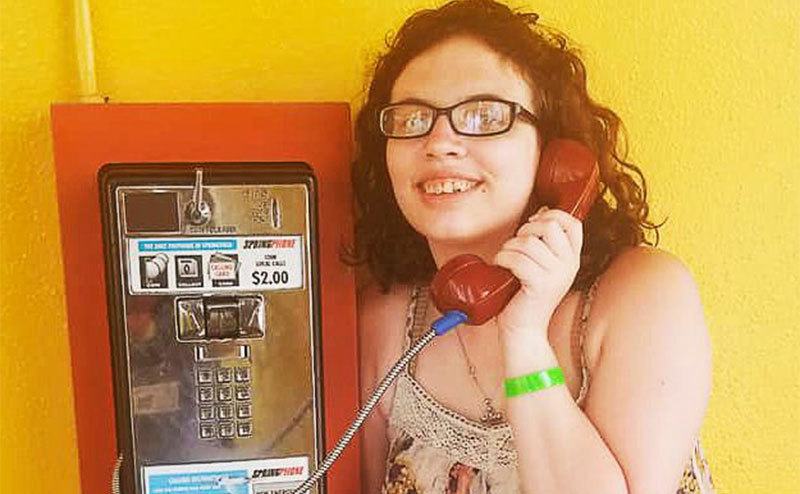 Hailey makes a phone call from a public pay telephone.