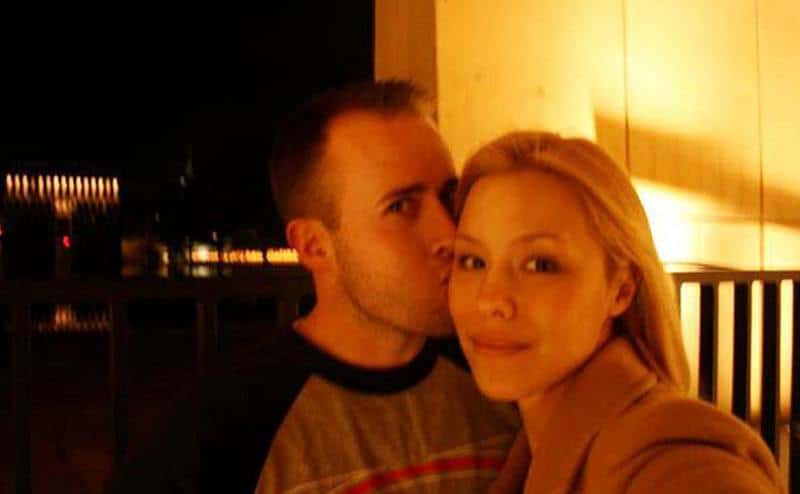 Jodi takes a photo with Travis as he kisses her.