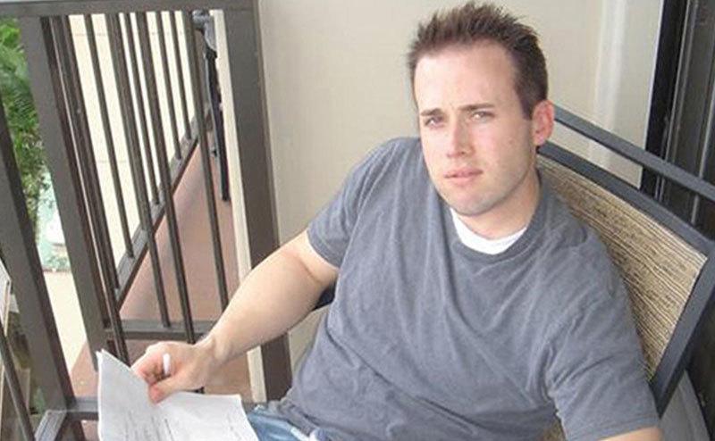 Travis sits on his balcony.