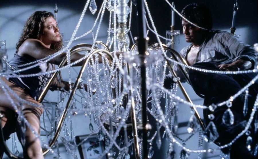 Kathleen Turner and Michael Douglas swing on a chandelier.