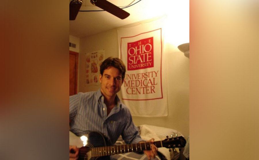 Brain plays his guitar in his medical school dorm room.