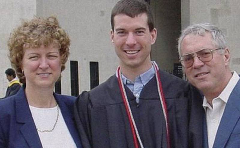 Brian poses with his parents at his graduation.