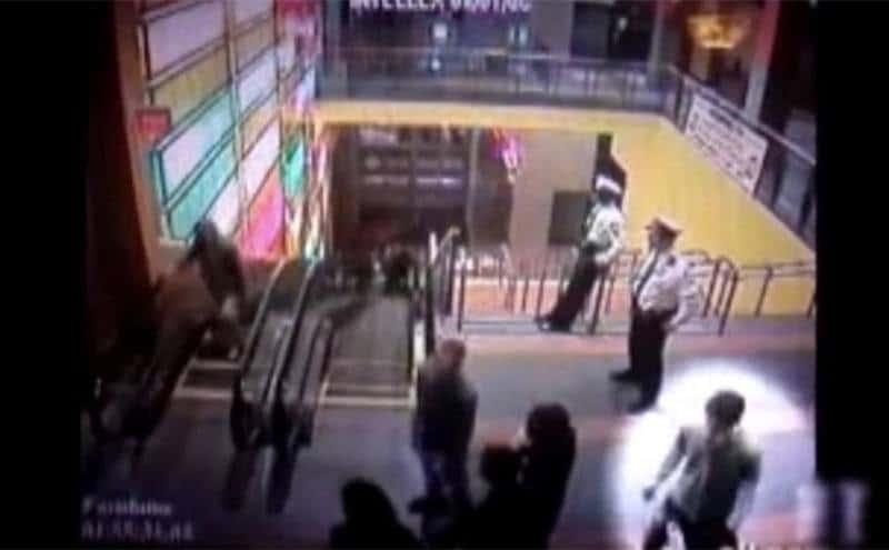 CCTV footage of Brain standing by the main entrance and talking to two women.