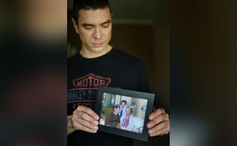 Derek Shaffer holds a picture of him with his brother Brian and their mother in the hospital.