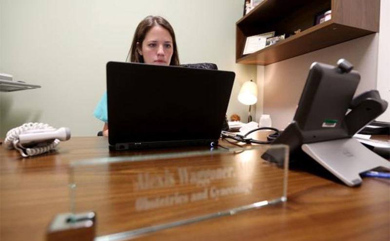 Alexis Waggoner sits in her office working on her computer.