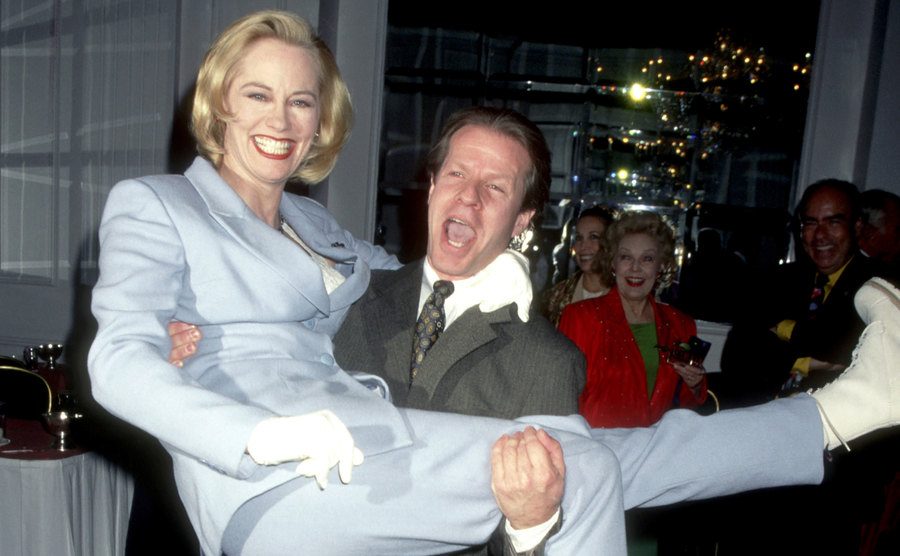 Cybill Shepherd is lifted in the arms of Robert Martin during an event.