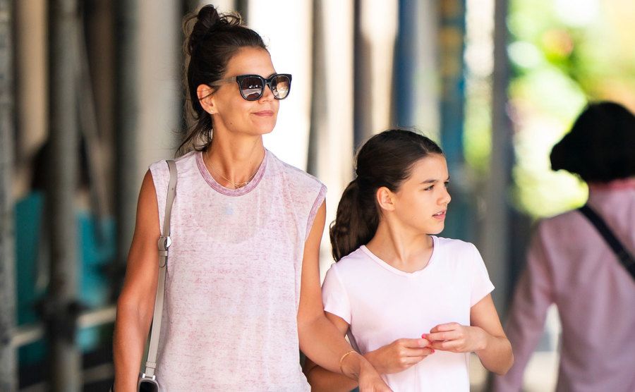 Holmes and Suri walk the street.