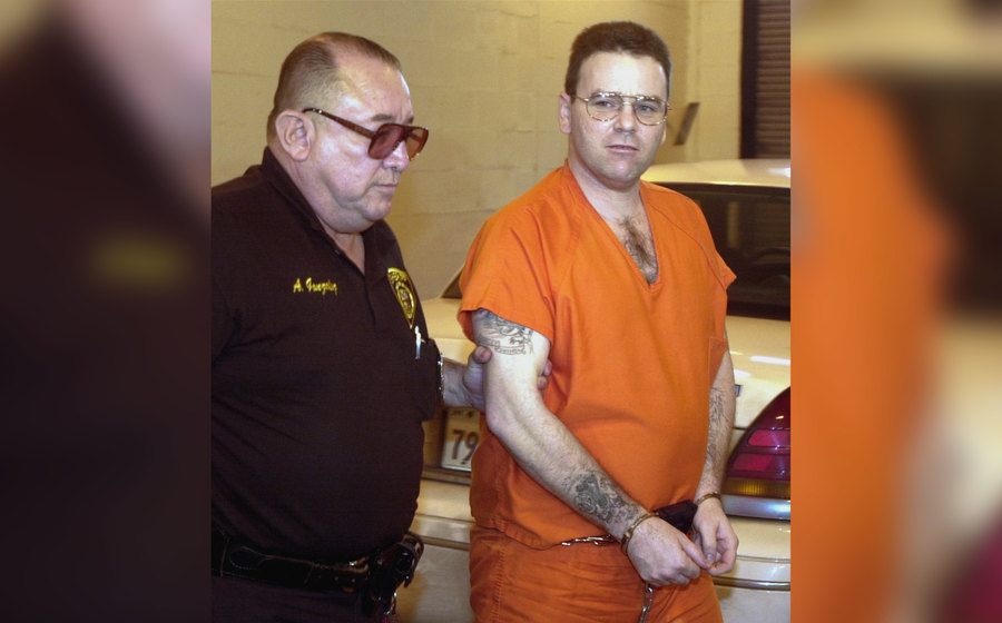 Tommy Lynn Sells is escorted in handcuffs by a police officer. 