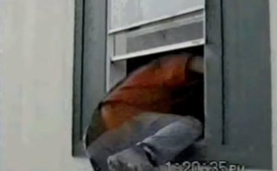 Tommy Sells shows detectives how he climbs in through the window. 