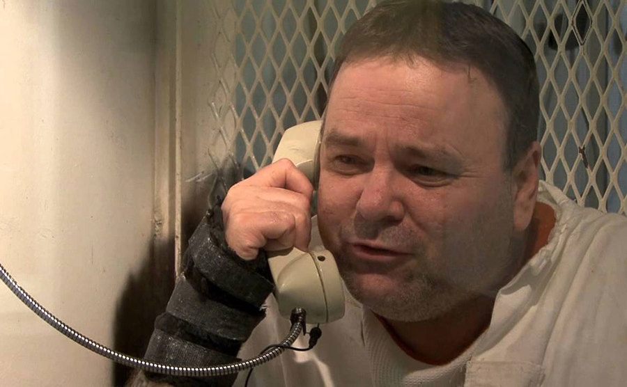 Tommy Sells answered questions through the glass in prison. 