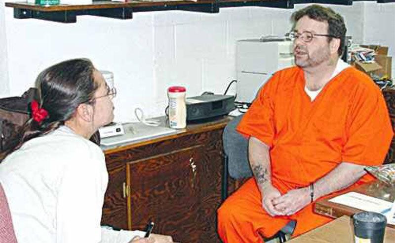 Sewlls sits in prison talking to a reporter. 