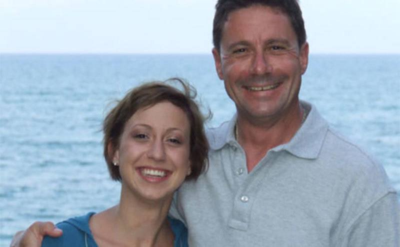 Krystal poses with her father on the waterfront. 