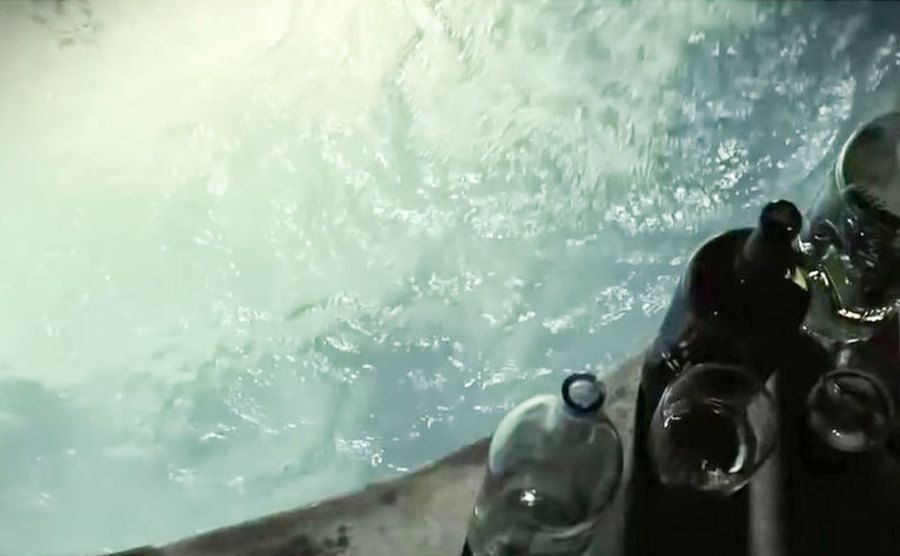 A photo of alcohol bottles by the swimming pool.