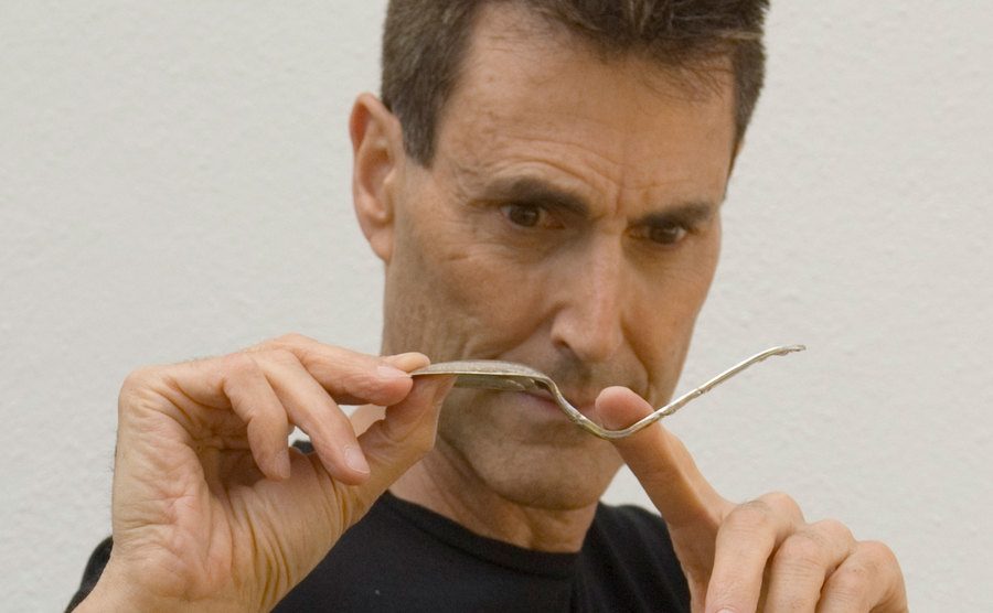 A photo of Uri Geller bending a spoon.
