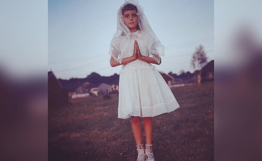 Susan Sarandon, as a young girl, poses in a white dress.