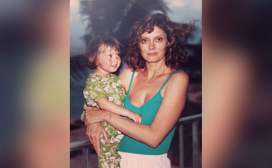Sarandon holds her daughter on her hip.