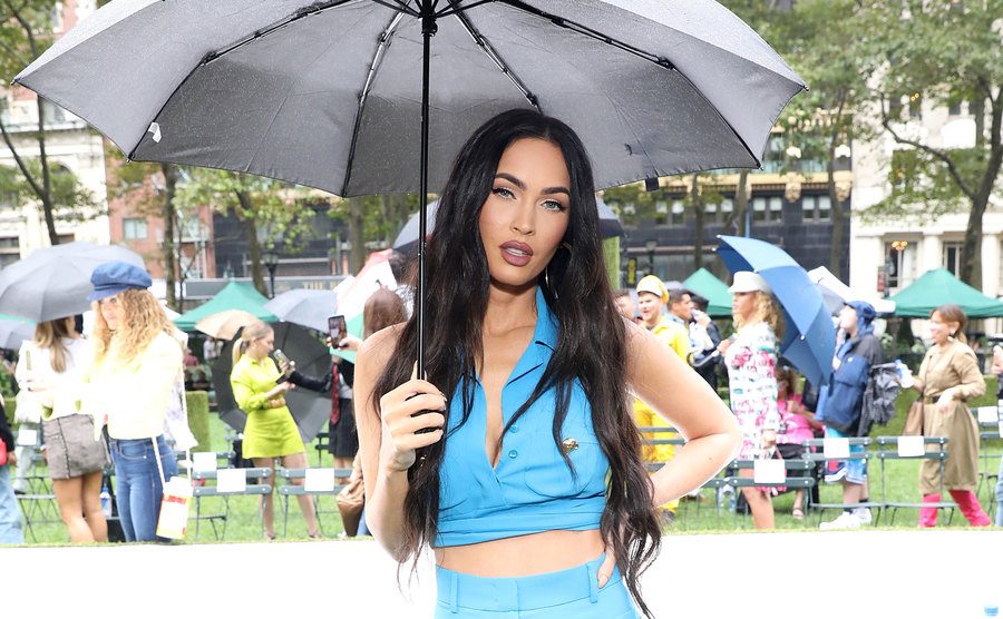 Megan Fox stands under her umbrella.