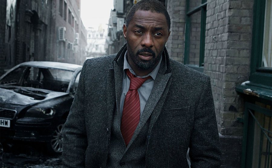 Idris Elba, as DCI John Luther, walks down the streets of London.