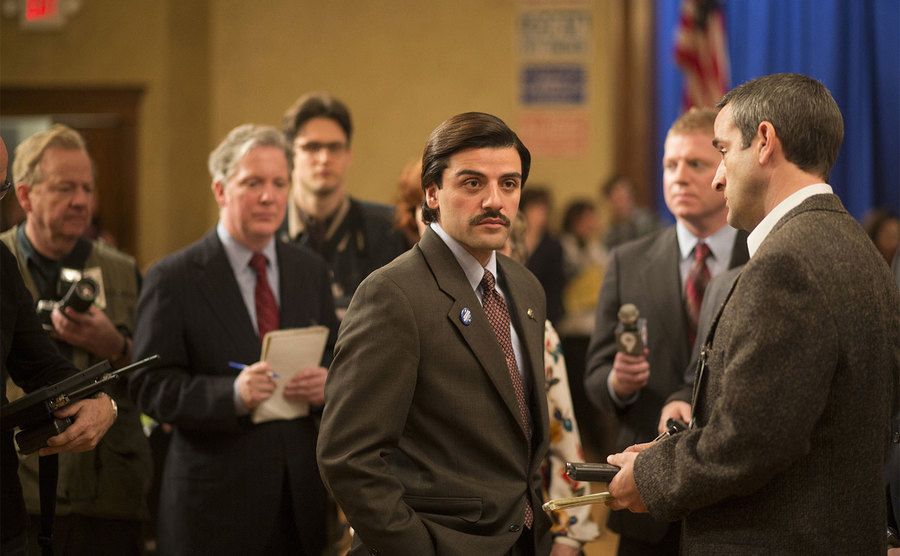 Oscar Isaac, as Nick Wasicsko, is bombarded by reporters.