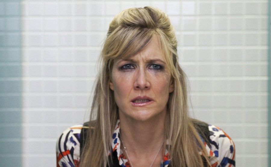 Laura Dern, as Amy, sits crying in a bathroom stall.