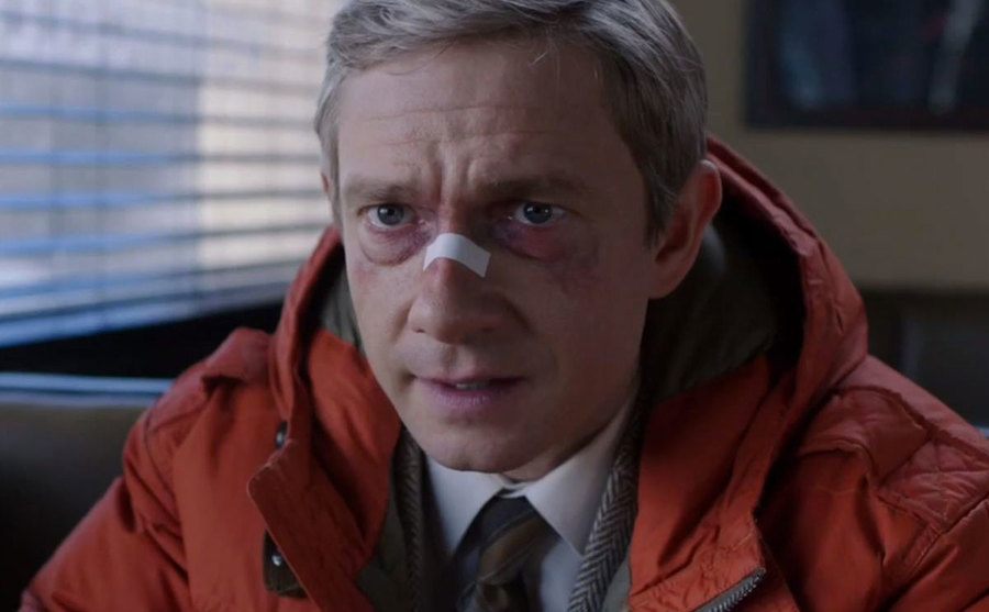 Martin Freeman, as Lester Nygaard, sits in a diner with a busted nose.