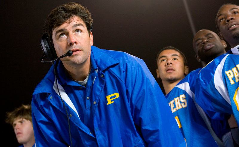 Kyle Chandler, as Eric Taylor, stands coaching from the sidelines.