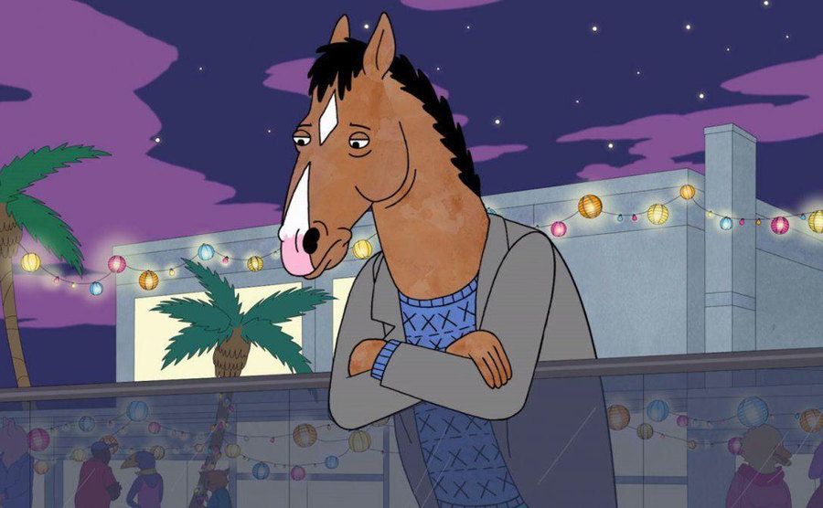 depressed BoJack Horseman looks off his balcony during a party.