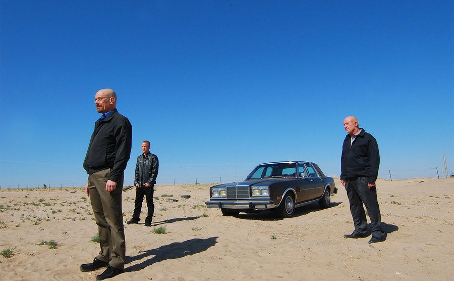 Bryan Cranston, Aaron Paul, and Jonathan Banks stand in the middle of the desert.