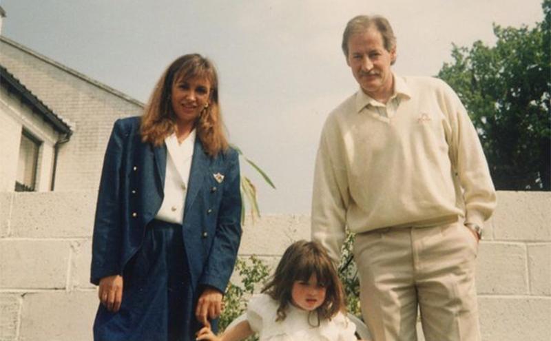 A young Rebecca takes a photo with her parents.