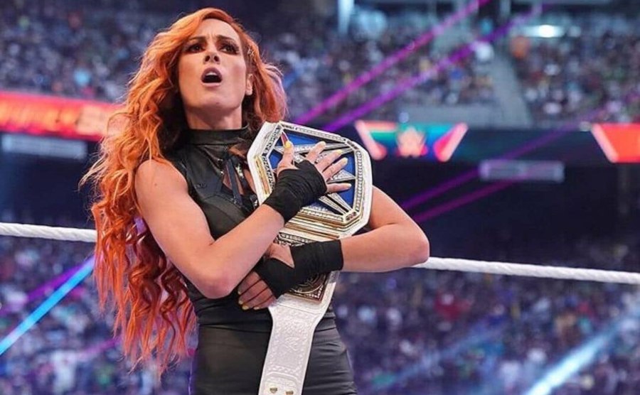 Becky walks her winning belt around the ring.
