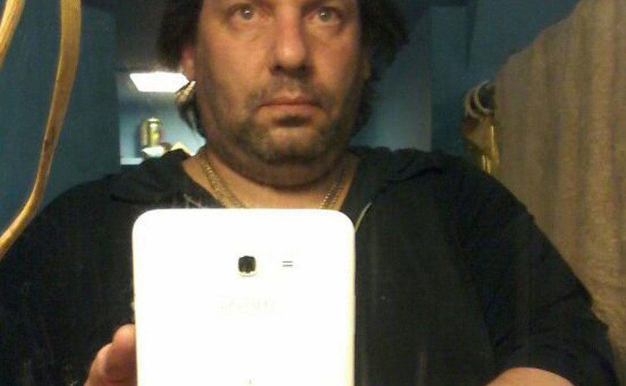 Adam takes a selfie in the mirror.
