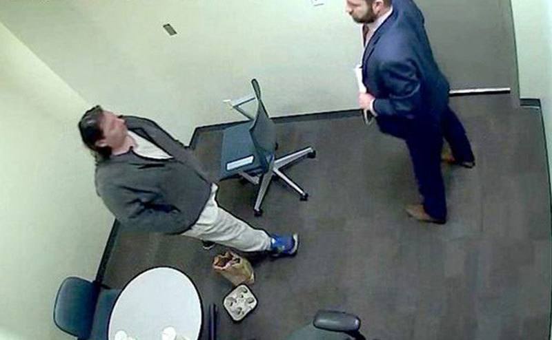 A security camera still of Adam in the interrogation room.