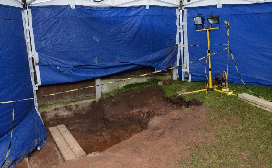 A picture of the uncovered shallow graves in the family garden.