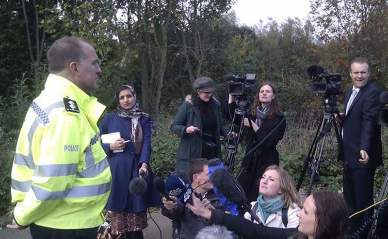 An inspector addresses the media next to the crime scene.