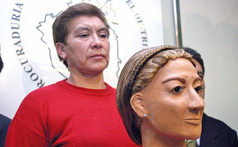 Juana Barraza stands next to police officers speaking to the media.