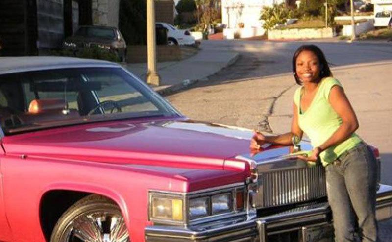 A participant poses next to her pimped car in a still from the show.