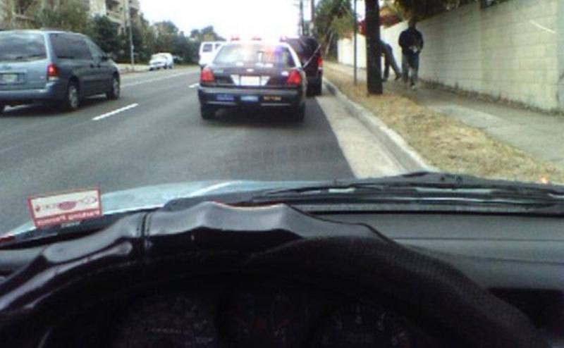 A photo of police coming towards a car.