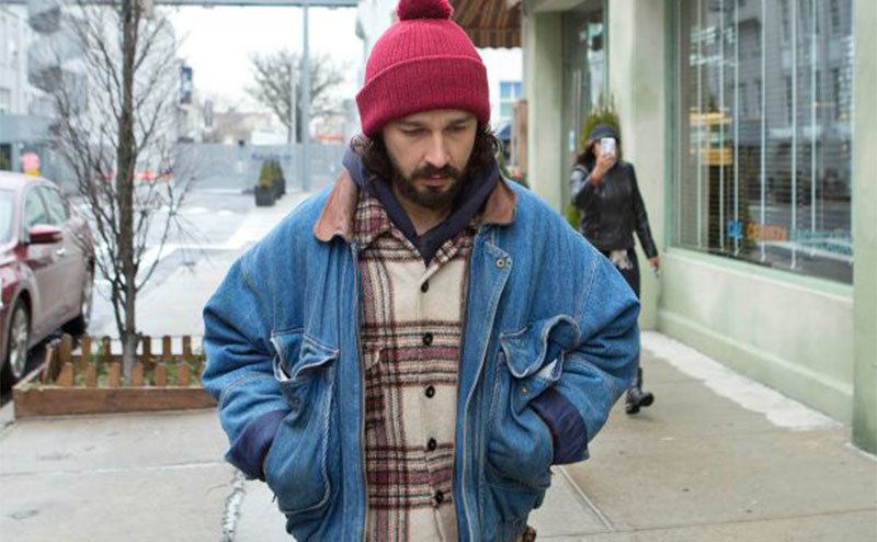 Shia walks down the street looking disheveled. 