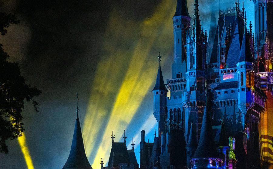 An image of multi-colored strobe lights illuminating Cinderella Castle at night.